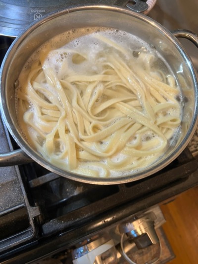 Fresh fettuccine boiling in a pot of salted water