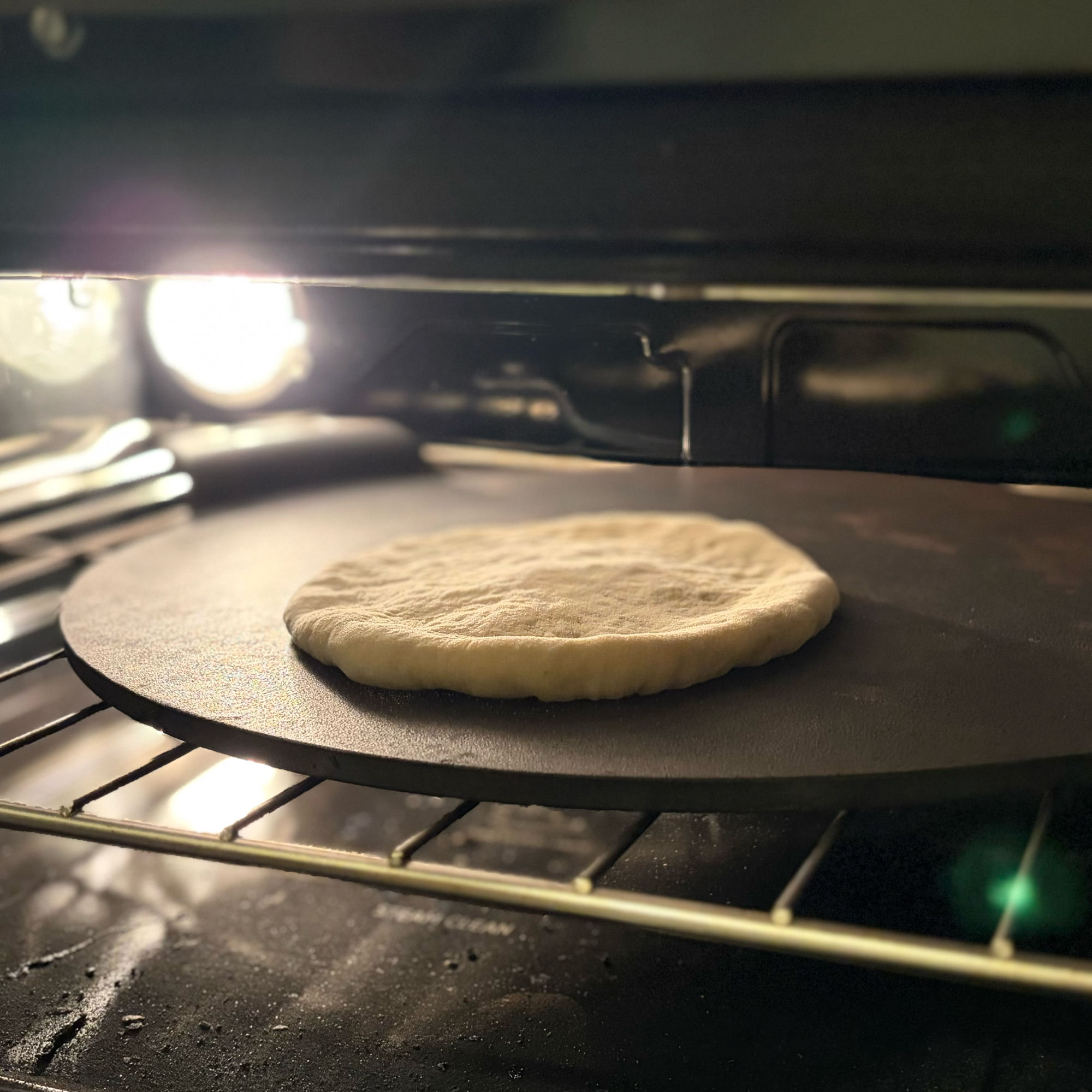 Naan baking on a steel in a regular oven