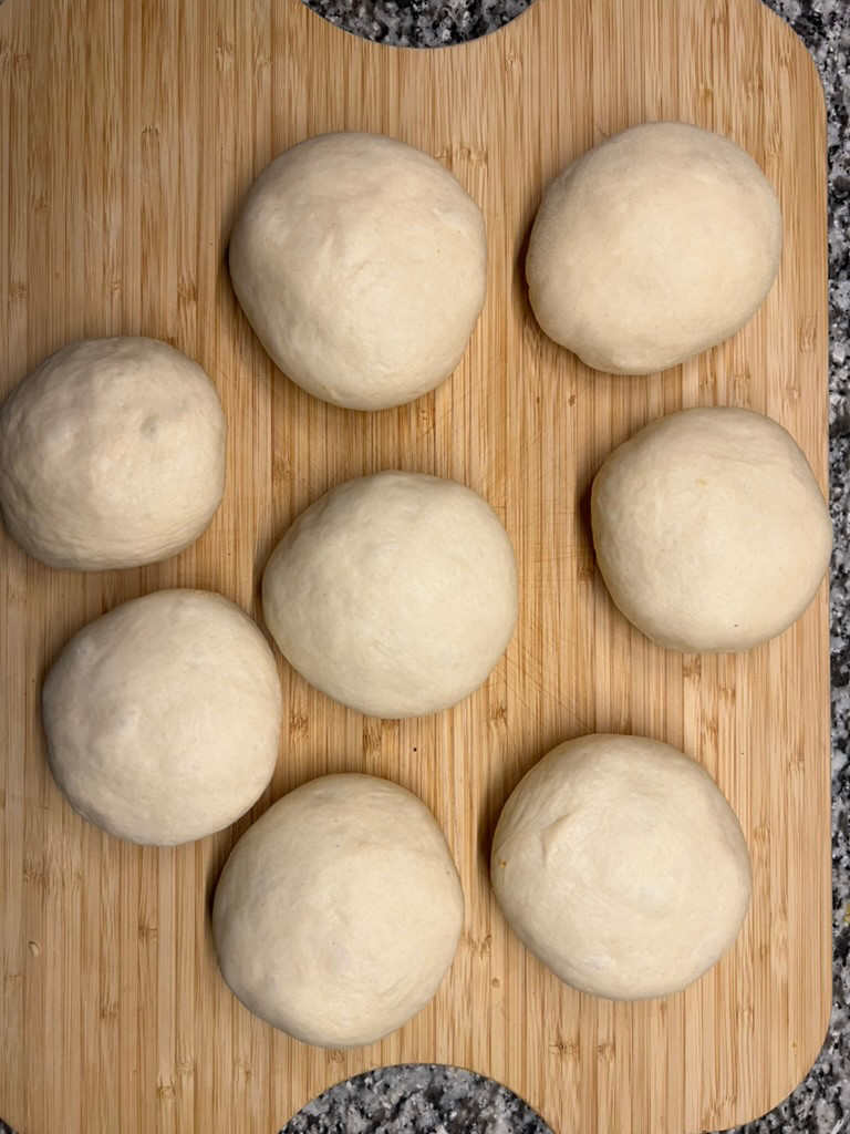 Sealed, stuffed dough balls resting seam side down