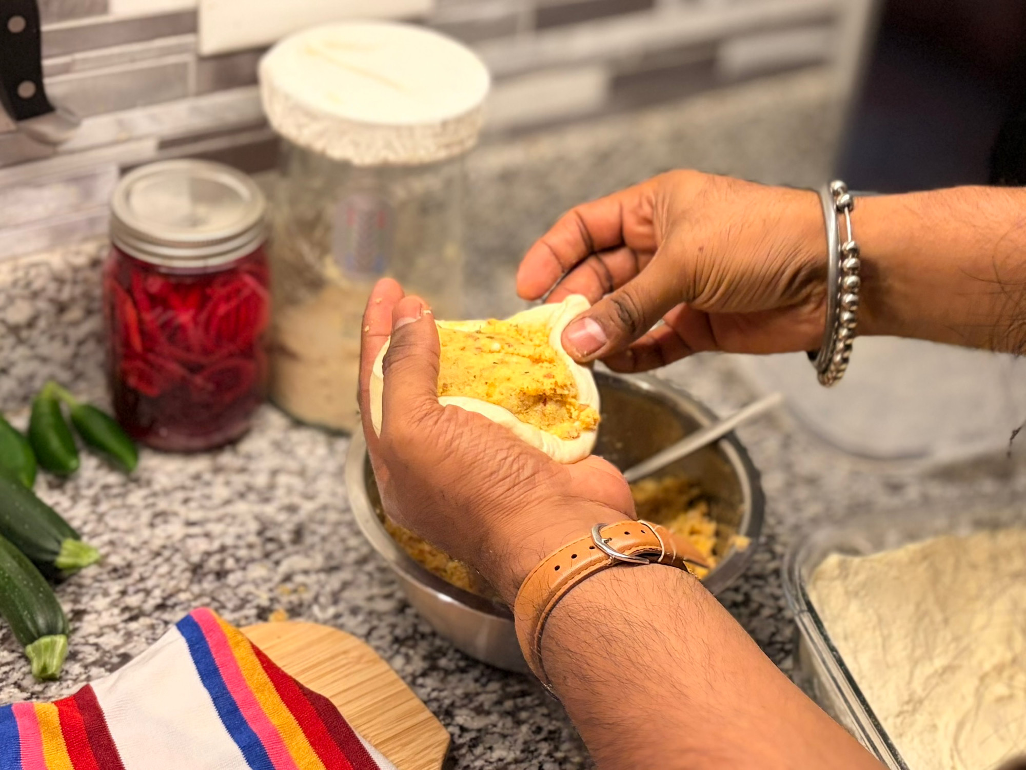 Sealing the edges of the dough over the potato filling